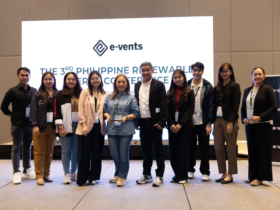 Conference organizers and participants posing together on stage