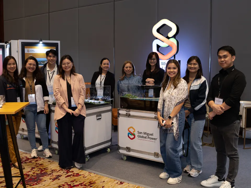 Exhibitors posing at a renewable energy conference booth